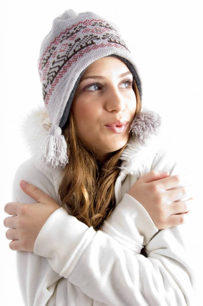 beautiful young female shivering in cold on an isolated background